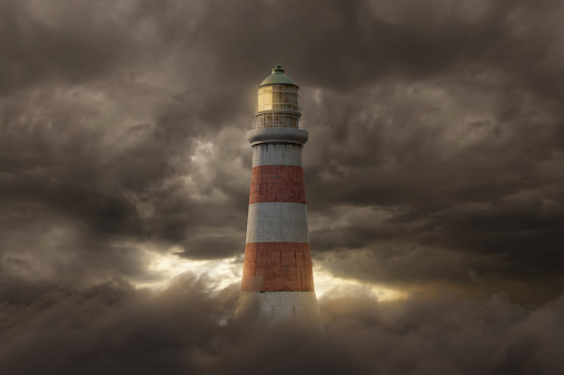 3d rendering of an illuminated lighthouse over fluffy clouds and dark sky