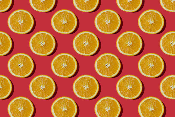 istock Summer composition made from oranges, on dark red  background. Creative Pattern made of slices of orange. Flat lay, top view of colorful fruit pattern of fresh orange slices on orange colorful background. 1367373580