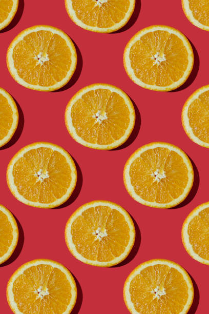 istock Summer composition made from oranges, on dark red  background. Creative Pattern made of slices of orange. Flat lay, top view of colorful fruit pattern of fresh orange slices on orange colorful background. 1367373653