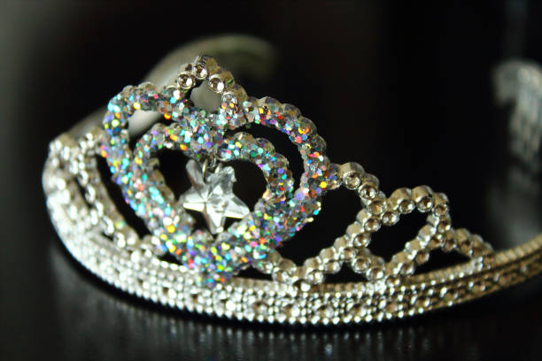 Beautiful plastic shiny baby crown. Bijouterie. Close-up. Background.