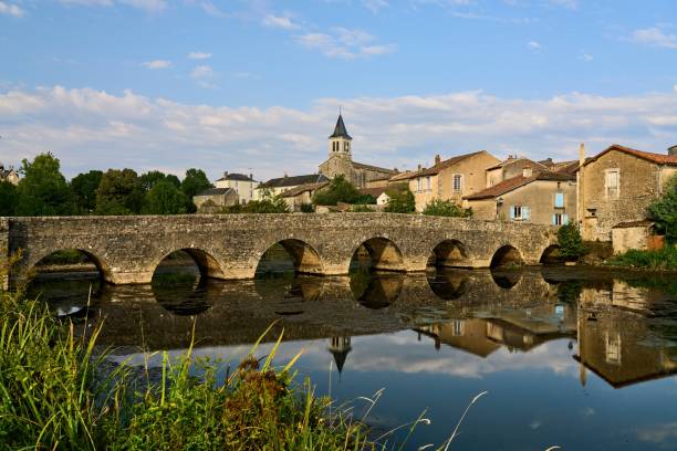 vista da igreja e da ponte de pedra medieval com 7 arcos de sanxay refletidos na superfície do vonne - urban scene building exterior reflection house - fotografias e filmes do acervo