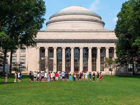 Cambridge, MA, USA - June 10, 2016: view of the architecture of the historic building of the Massachusetts Institute of Tech nology, MIT, in Cambridge, MA, USA with lots of students passing by.