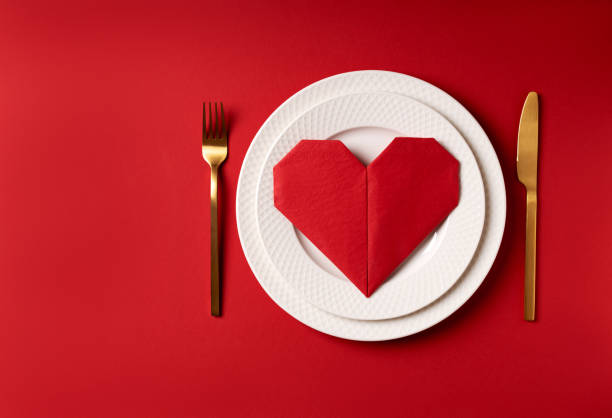 istock Red napkin heart on white plates. 1367379030