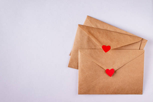 istock craft envelopes with red paper hearts on white background, copy space 1367380197