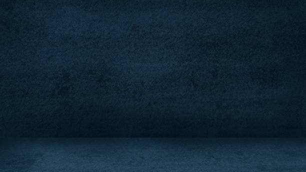 istock image of blank dark blue concrete interior room background. rustic wall and floor indoors concept with dark corners. abstract room for product displayed. 1367381549