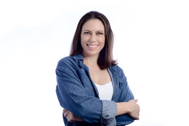 istock Young woman with arms crossed looking at camera in studio with white background 1367382671