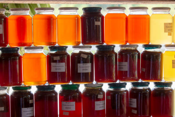 Pots and bottles of honey on outdoor market shelf with backlight glow, for sale in a roadside market in the interior of the State of São Paulo, Brazil
