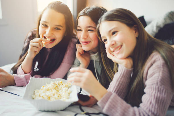 istock A pajama party with teens eat popcorn on the bed 1367383648