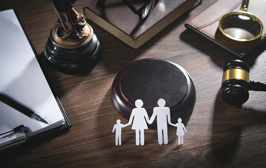 Paper cut family, judge gavel, book and other objects. Family Law