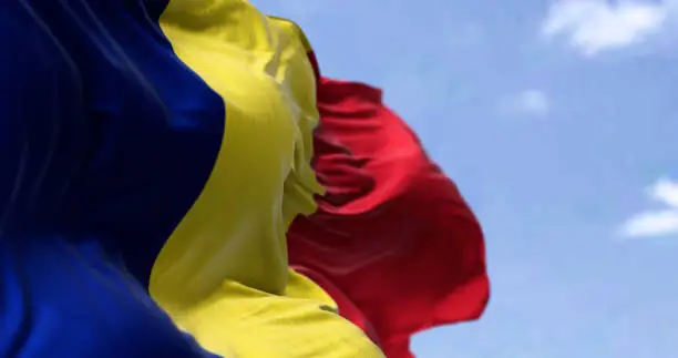 Detail of the national flag of Romania waving in the wind on a clear day. Democracy and politics. Eastern Europe country. Patriotism. Selective focus.