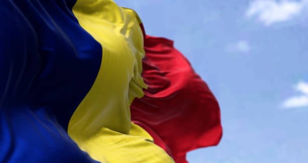 detail of the national flag of romania waving in the wind on a clear day - romania imagens e fotografias de stock