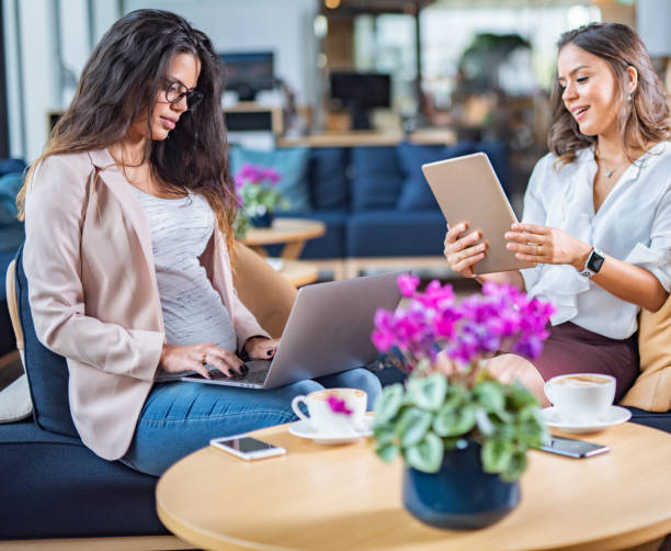 istock Two happy female coworkers using digital tablet and laptop 1367386132