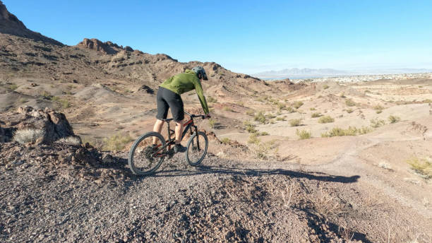 istock Mountain biker follows desert pathway 1367386258