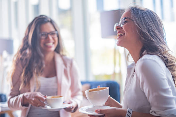 istock Two happy females drinking coffee 1367386357