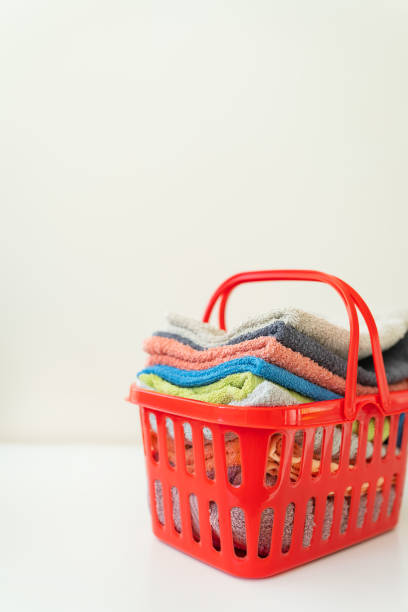 istock Multi-colored towels lie in a red laundry basket on a white background. Laundry and ironing. 1367388057