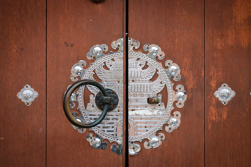 Silver ornaments at traditional old Korean wooden door
