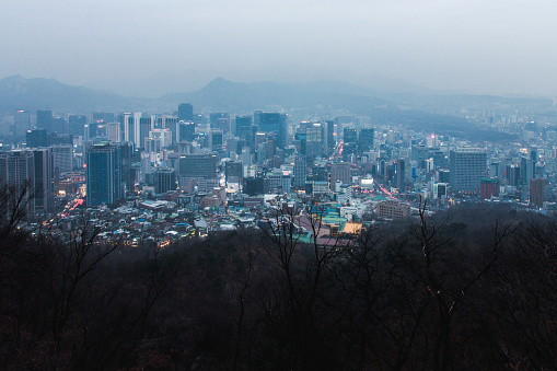 Cityscape Seoul seen from Namsan Mountain Park on a foggy misty hazy afternoon in winter against cloudy sky