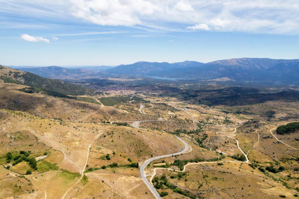 istock Aerial panoramic drone point of view road surrounded by lands and meadows 1367389537