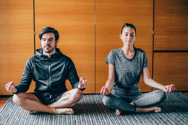 istock Young couple meditating in Lotus position at home. 1367390498