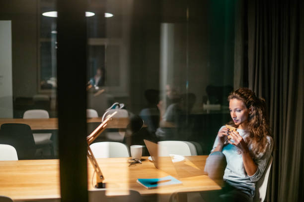 businesswoman working late in the office. - eating sandwich emotional stress food imagens e fotografias de stock