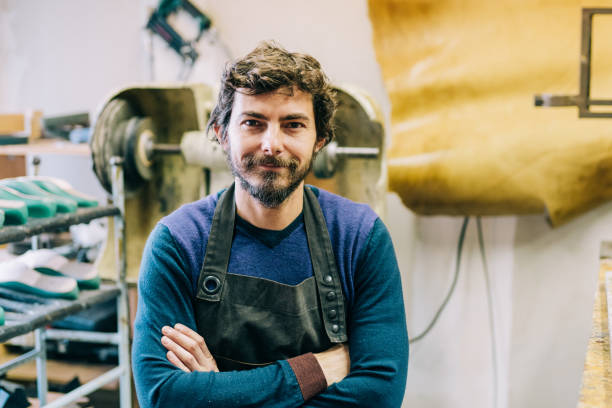 Portrait of male shoemaker. Shot of young craftsperson standing with crossed arms and looking at camera in his workshop. shoe mold stock pictures, royalty-free photos & images