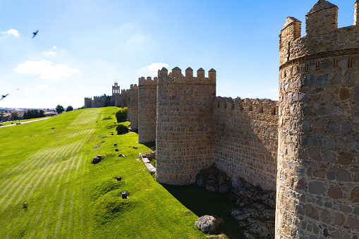 Drone point of view The Walls of Avila historic city, against blue sky during sunny day. Famous fortification, spanish landmark in Castile and Leon. UNESCO. Spain