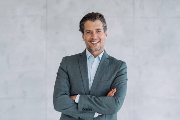 Portrait of successful businessman. Portrait of handsome confident smiling businessman standing in the office and looking at camera. real estate agent male stock pictures, royalty-free photos & images