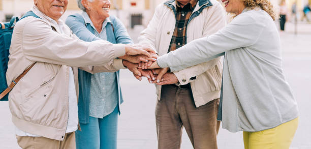 istock Senior men and women stack their hands together in solidarity. 1367391569
