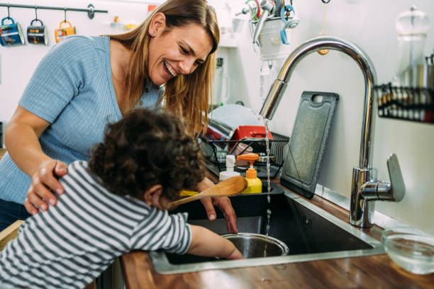 istock Mother and little son washing dishes. 1367391582