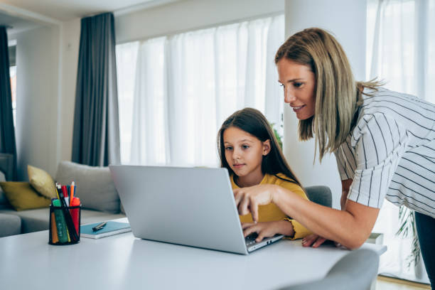 istock Mother and daughter studying online at home. 1367391849
