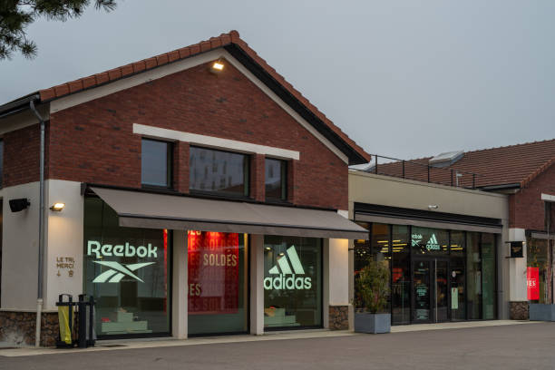 Romainville cityscape Romainville, France - January 13 2022: Adidas and Reebok outlet store in Paddock Paris EST Factory Outlet village near Paris on a cloudy winter morning. reebok stock pictures, royalty-free photos & images