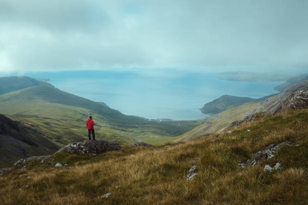 A hiker at the top of the mountain views the magnificent landscape of the sea bay stock photo