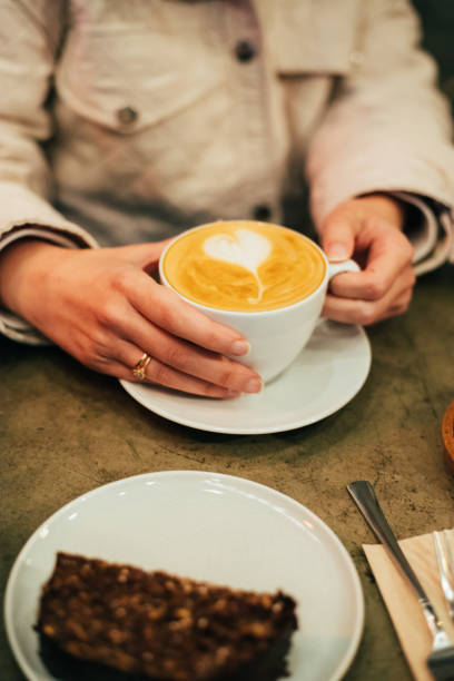 istock Woman holding a cup of latte 1367393526