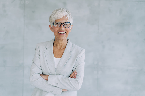 Portrait of a happy caucasian businesswoman standing with her arms crossed at work. One confident female manager standing in an office at work. One content expert business professional at work