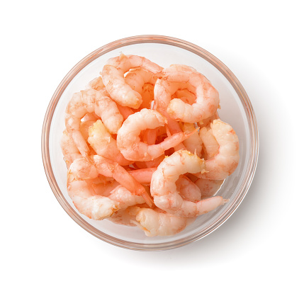 Top view of bowl with boiled peeled shrimps isolated on white