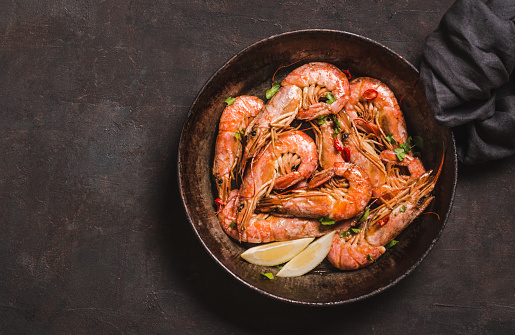 Argentine shrimps cooked roasted on dark background copy space.