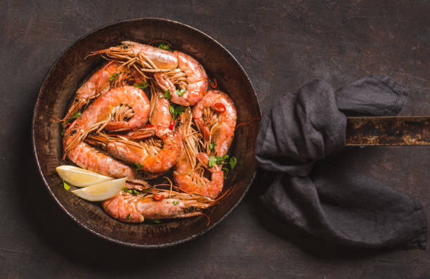Shrimps roasted on dark background copy space.