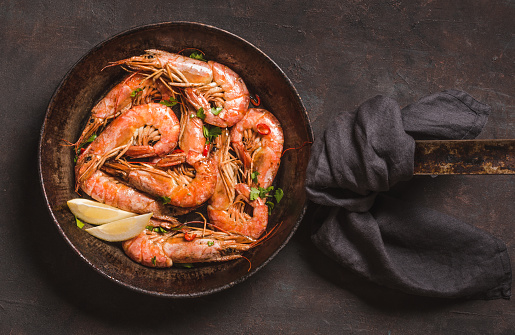 Argentine shrimps cooked roasted on dark background copy space.