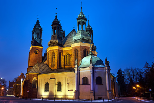 the historic towers of the Gothic cathedral at night in Poznan