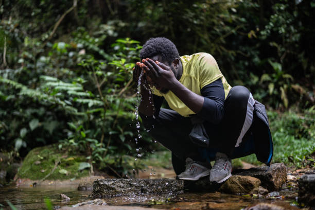istock Young man washing his face in the forest 1367398639
