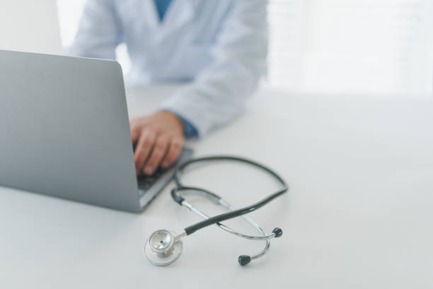 istock Doctor at his desk working on laptop. 1367398696