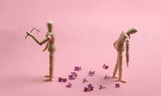 Broken heart. Two puppets on a pink background. Parting, attitude