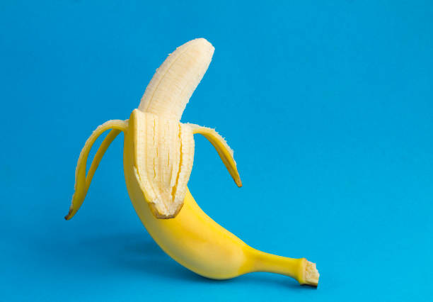 istock Close-up on peeled banana on the blue background. Copy space. 1367399696