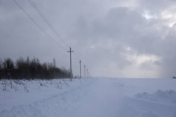 istock A deserted country road through snow-covered fields. 1367399836
