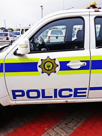 Cape Town, South Africa - January 28, 2022: A van emblazoned with the logo and colors of the South African Police Service parked in the emergency zone outside a shopping mall in the southern suburbs of Cape Town.