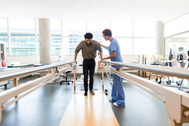 istock Man with injured foot has long walk at physical therapy 1367401305