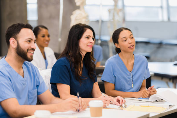 istock Multi-ethnic nursing students smile and listen to unseen teacher 1367402238