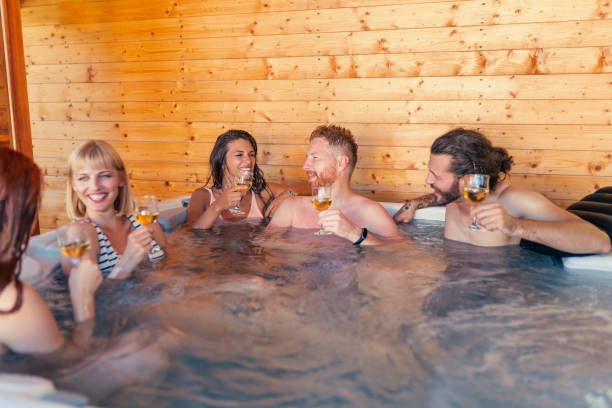 istock Friends drinking wine and relaxing in hot tub 1367404113