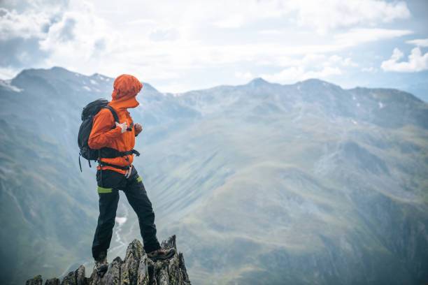 Mountaineer scrambles up summit of pinnacle stock photo