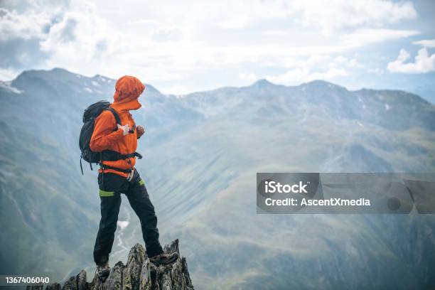 Mountaineer Scrambles Up Summit Of Pinnacle Stock Photo - Download Image Now - Mountain Peak, People, Sustainable Lifestyle